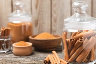 Cinnamon sticks on a textured wooden background. Cinnamon roll. Spicy spice for baking, desserts and drinks. Fragrant ground cinnamon. cinnamon powder Close-up. Place for text. copy space; Shutterstock ID 2471865781; purchase_order: -; job: -; client: -; other: -